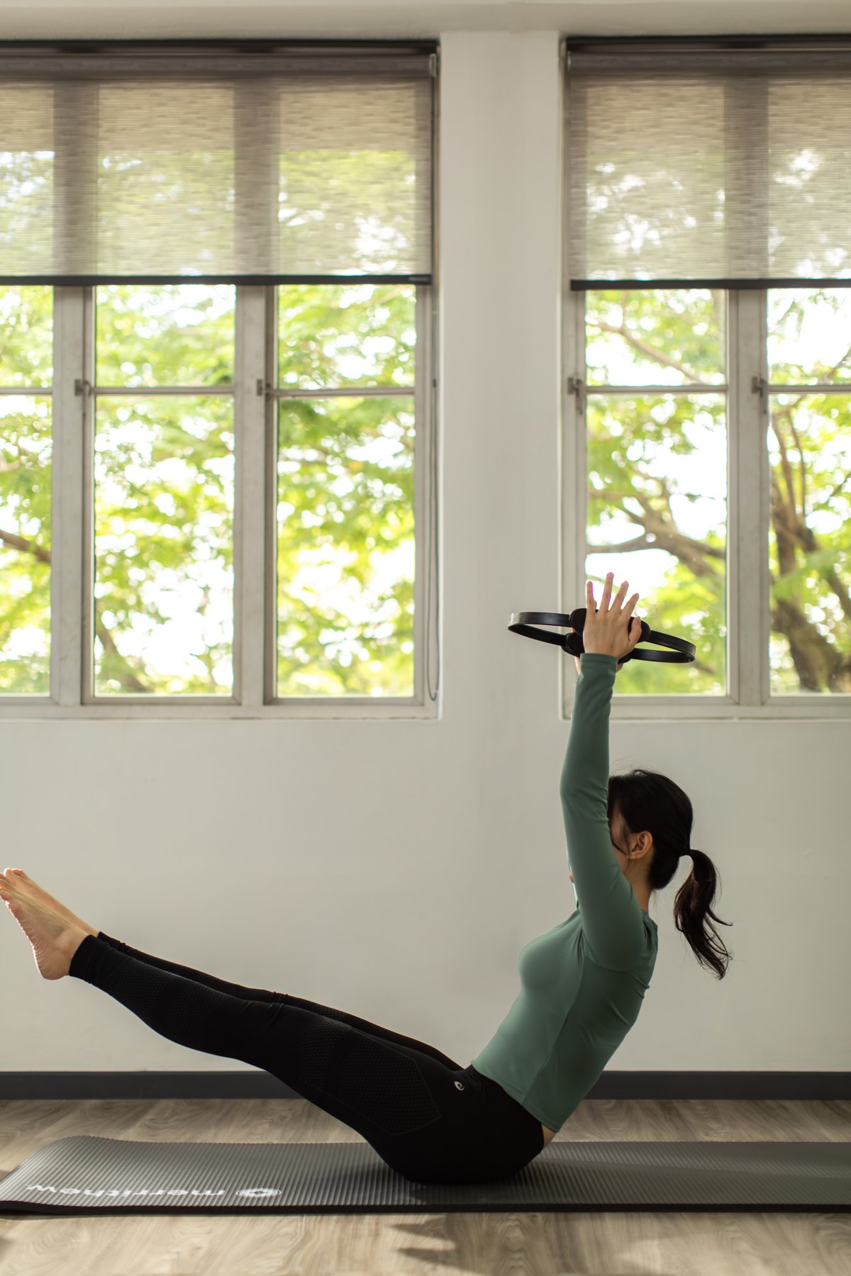 Participant practising mat Pilates with a Pilates ring at Meranti studio