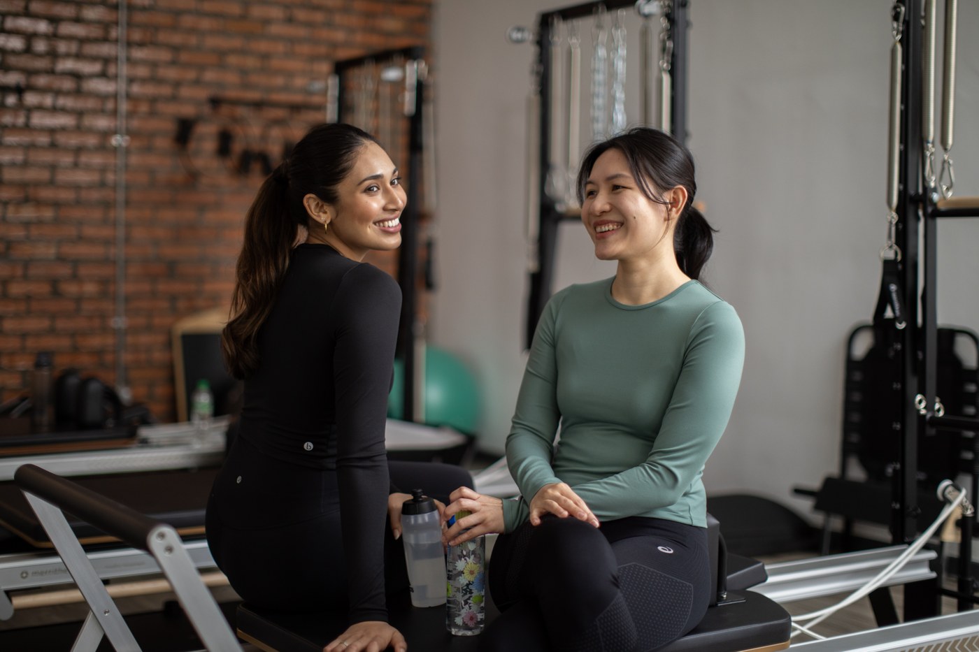 Two women seated together at Meranti Pilates Studio in Bangsar